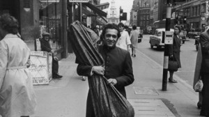 ravi shankar walking on street with sitar in his hand